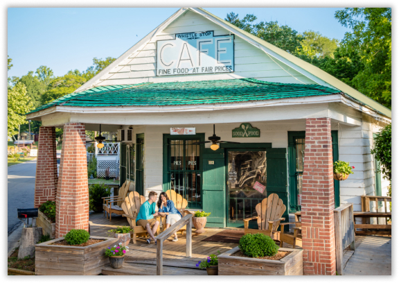 old country cafe with front porch and people sitting in Adirondack chairs