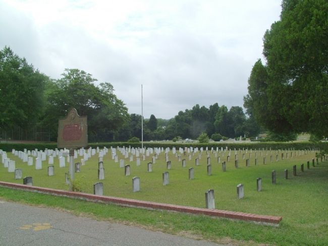 Graveyard of matching short headstones with roadside historic marker