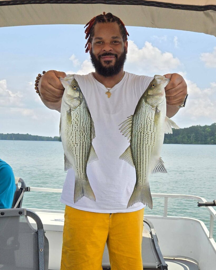 A guest on All Seasons Guide Service holding up two fish.