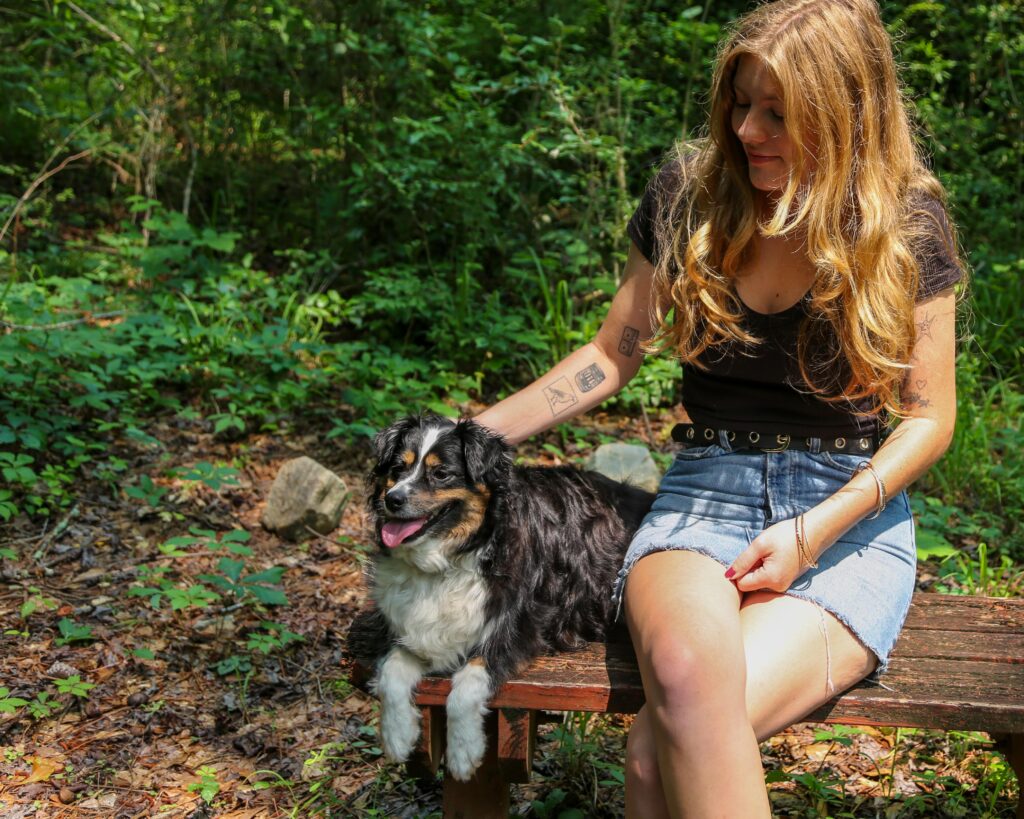 A young girl sitting on a bench at High Falls State Park with her dog.