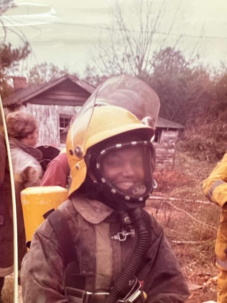 young african american female in 1970s firefighter uniform and helmet