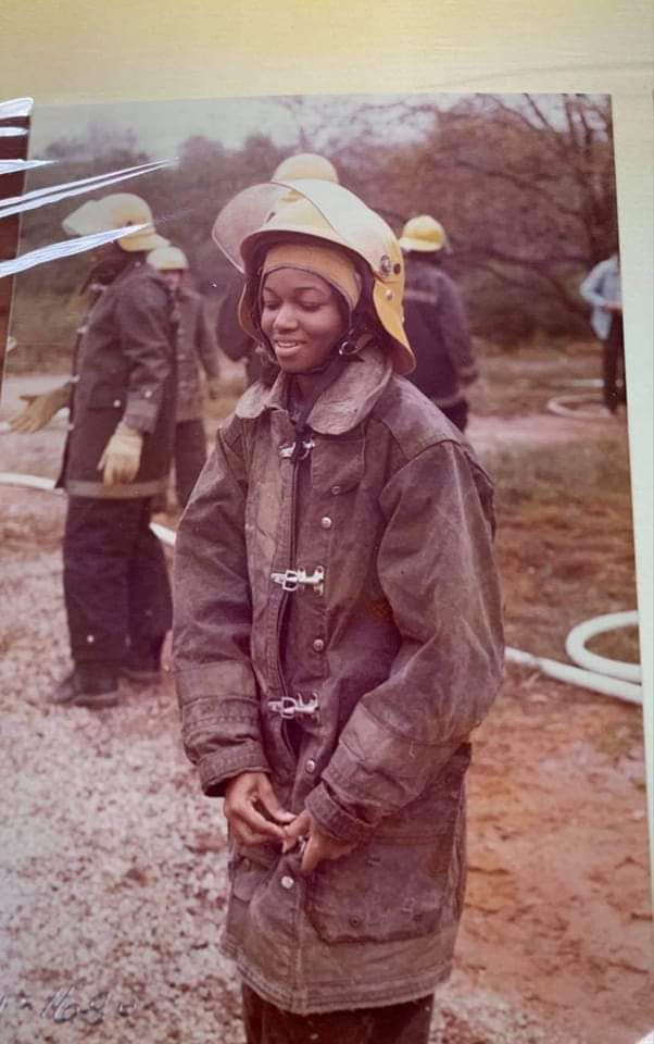 young african american female in 1970s firefighter uniform and helmet