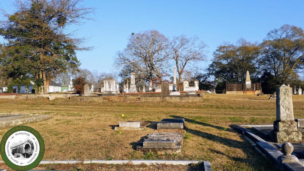 Looking at a cemetery from a distance, monuments peaking above the grass