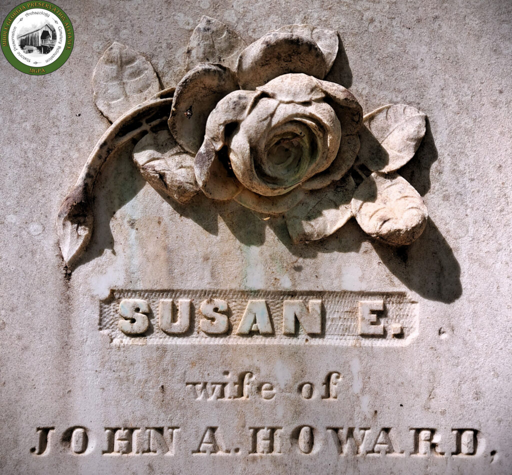 close up detail of a rose carved on a marble headstone
