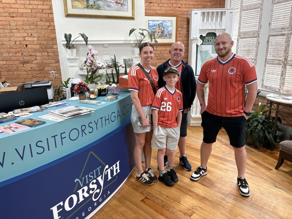 World Cup fans pose inside lobby of Visit Forsyth GA Welcome Center