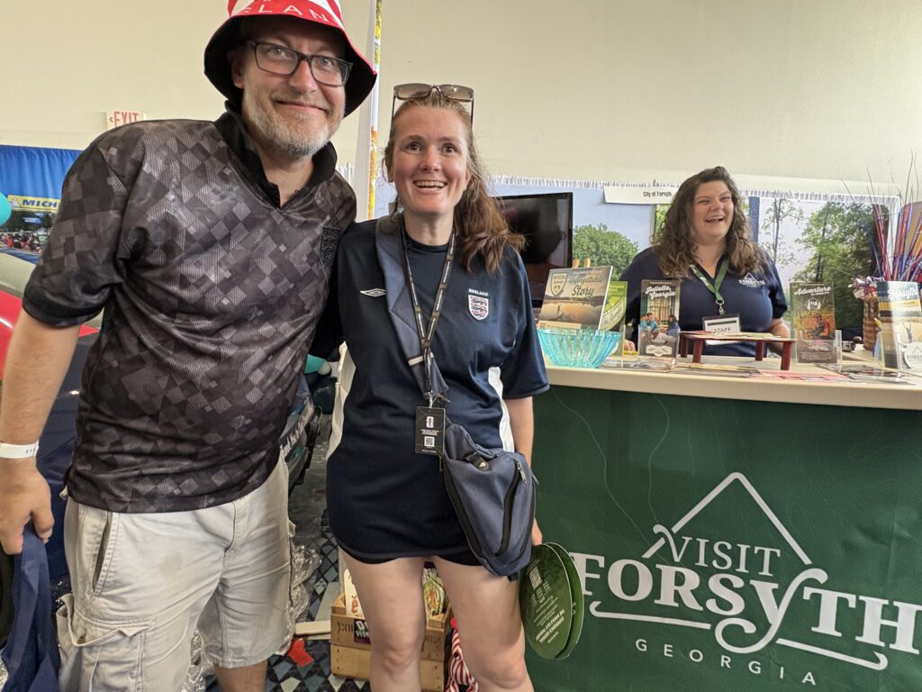 World cup fans pose in front of Visit Forsyth GA booth