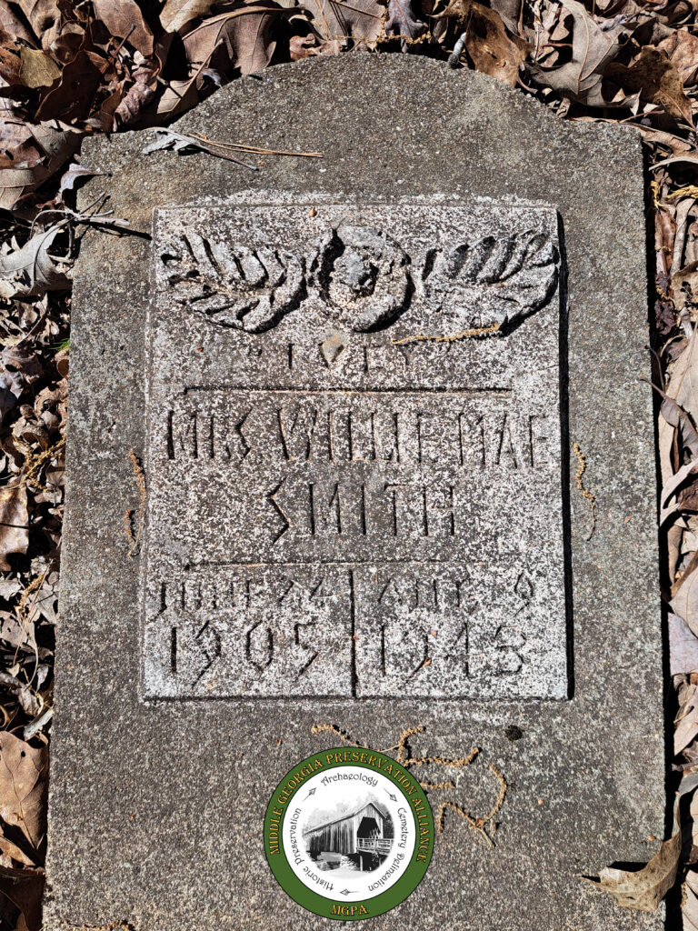 concrete headstone with plaster on face carved with names and dates