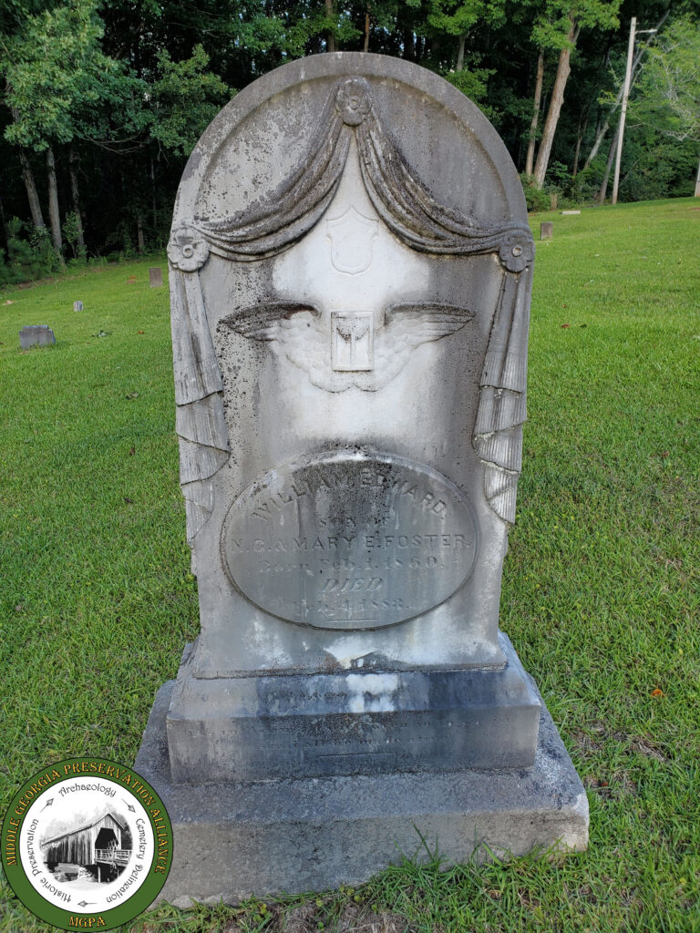 headstone with carved curtains and winged design