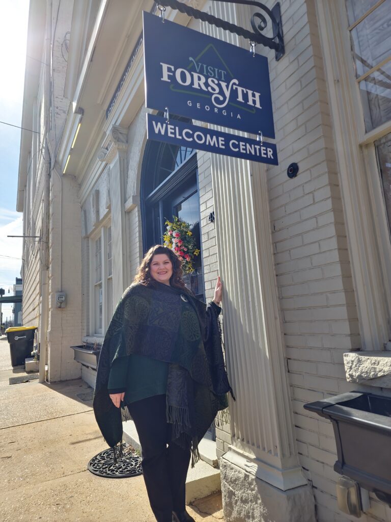 Woman (Nicole Newsom) stands in front of Forsyth Welcome Center sign
