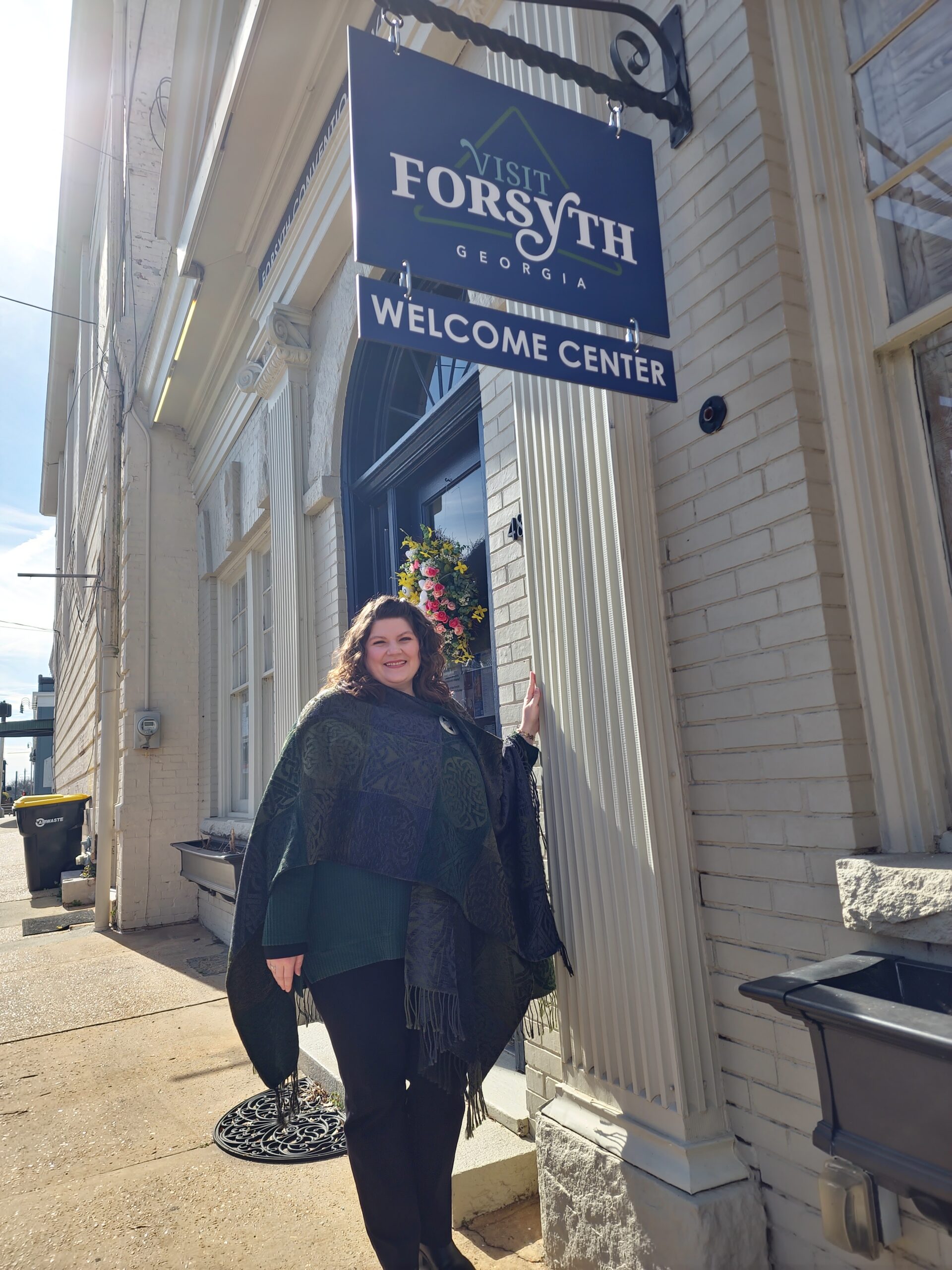 Woman (Nicole Newsom) stands in front of Forsyth Welcome Center sign