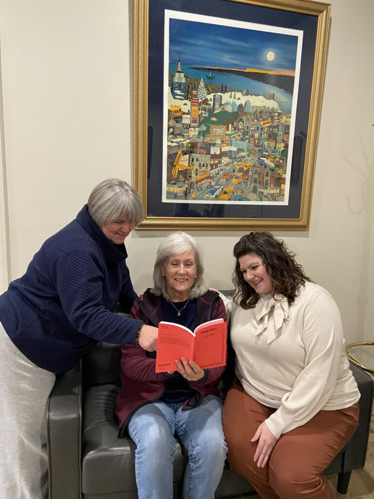 Nicole Newsom with Abbie Bunn and Jane Walker looking at a book at the Rose Theater.