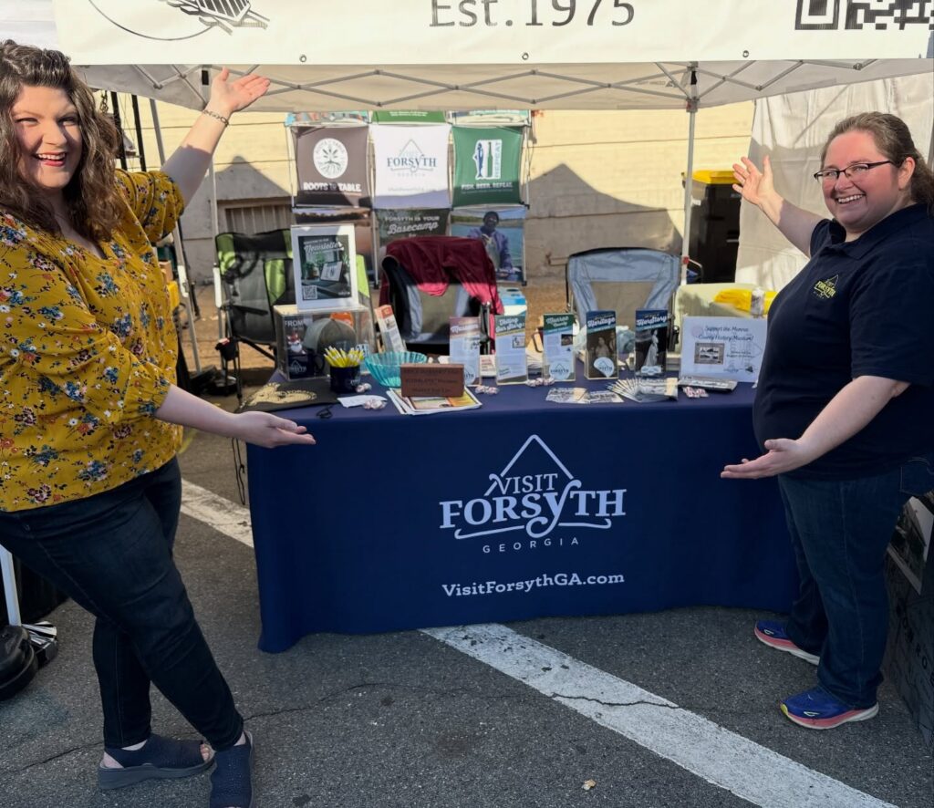 Visit Forsyth GA booth displaying local visitor information at the Forsythia Festival.