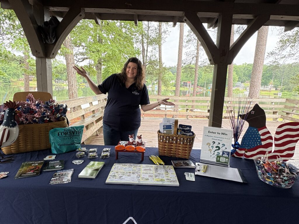 woman (Nicole Newsom) stands behind outdoor information table at High Falls State Park