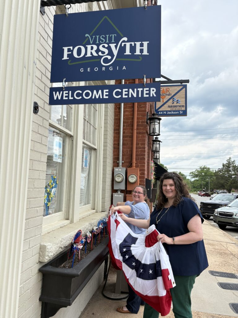 Nicole Newsom and Chelsea Bunn Kerr decorating the Forsyth Welcome Center with patriotic bunting.