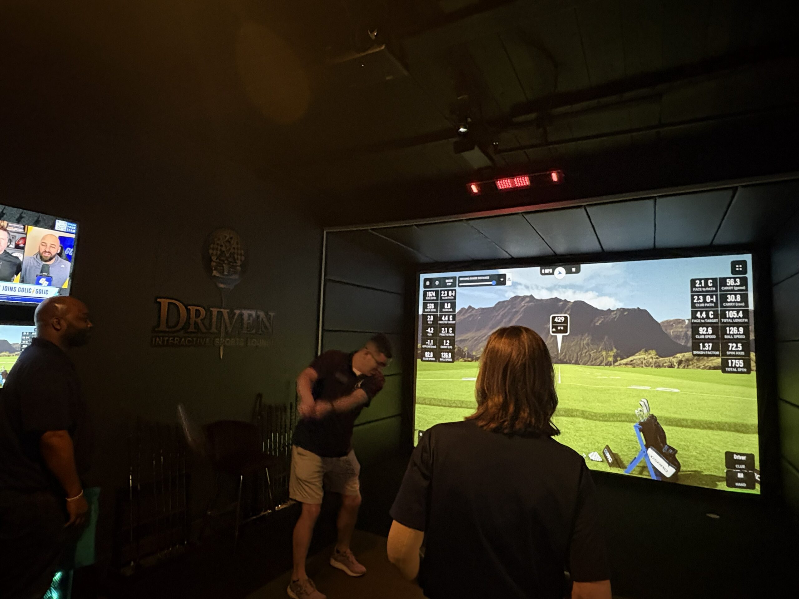 man putts golf at indoor golf simulator