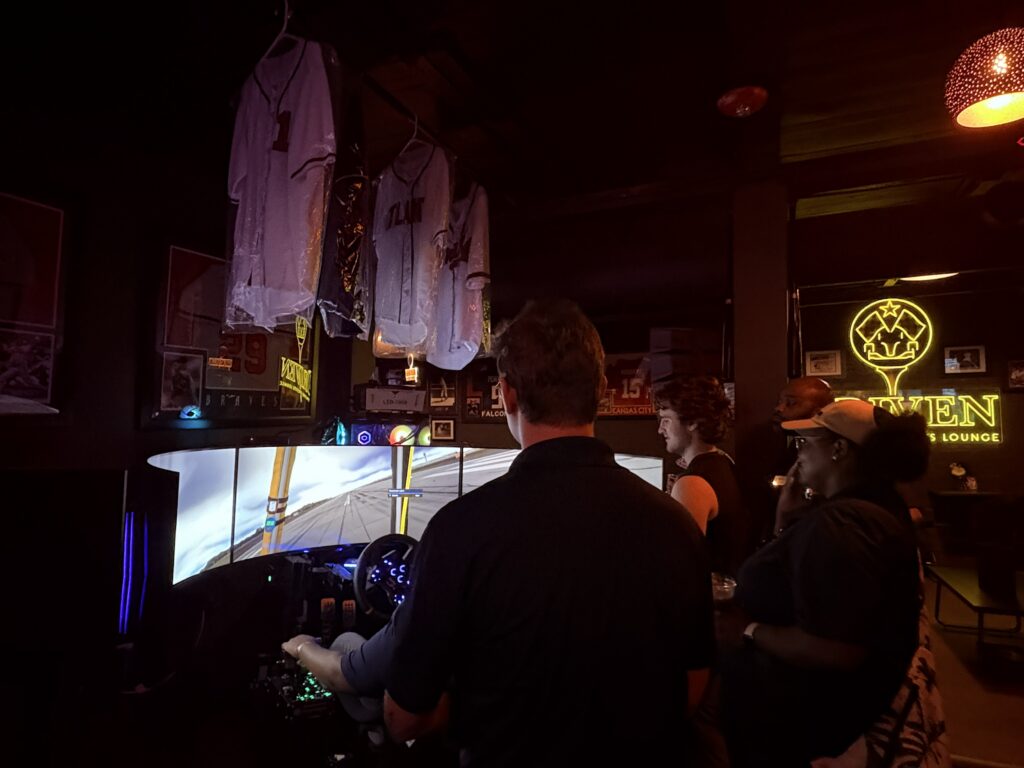 people watch driver on indoor racing simulator
