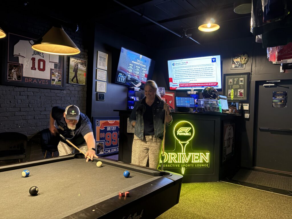 man and woman play pool at driven