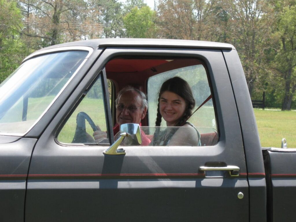 Nicole Newsom and her grandfather sitting in a pickup truck on the family farm.